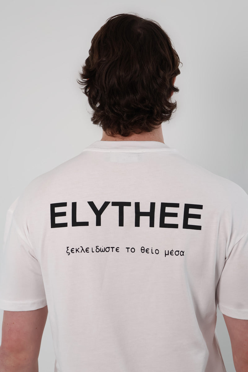 Wearing the Legacy T-Shirt - Unisex, one sports ELYTHEE and Greek text on the back. Made from premium breathable cotton, this classic piece blends bold minimalism with style and comfort.