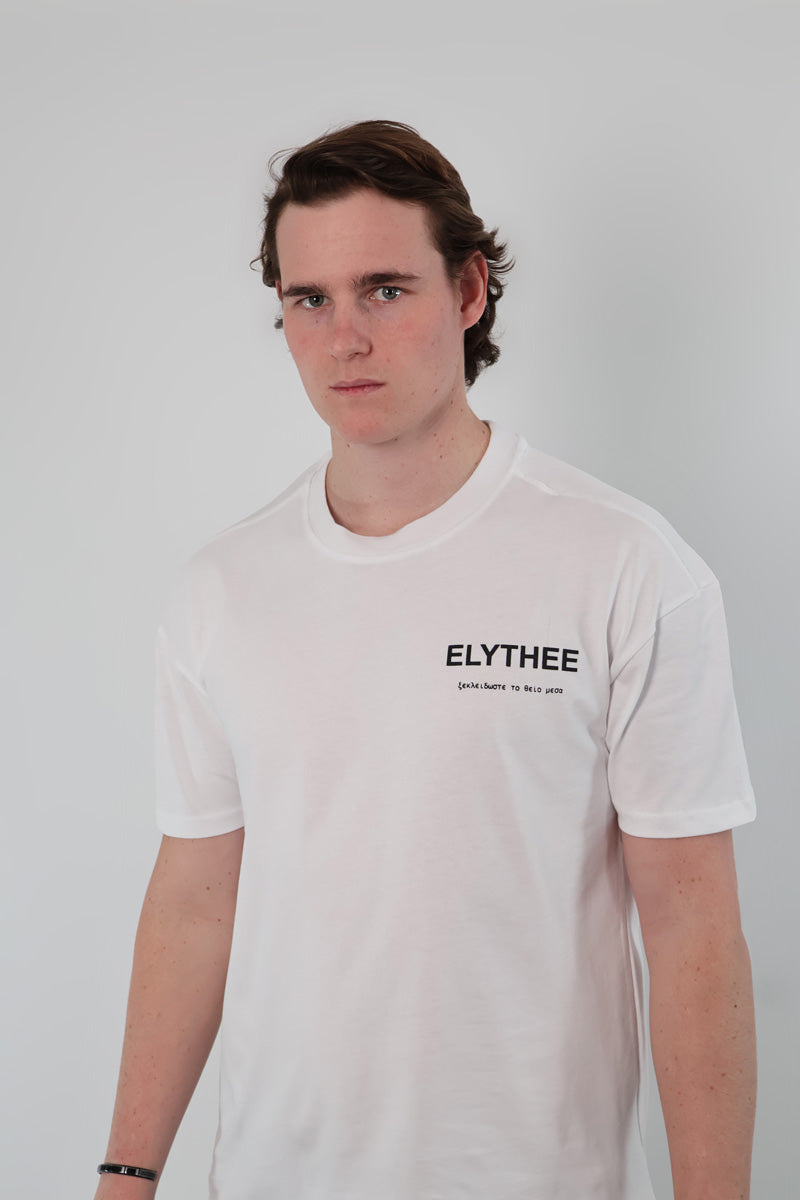 A person wears the Legacy T-Shirt - Unisex, a minimalist bold piece crafted from premium breathable cotton, standing confidently against a plain background.