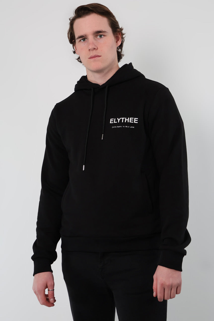 A person wearing the Mythos Essence Hoodie, which features ELYTHEE on it, stands against a plain backdrop.