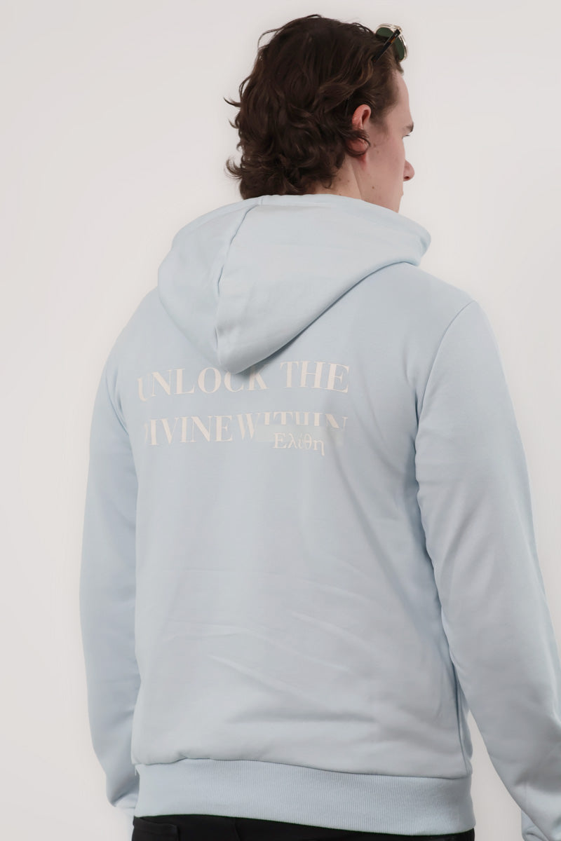 A person wearing the Mythos Essence Hoodie, light blue with white text on the back, stands against a white background.