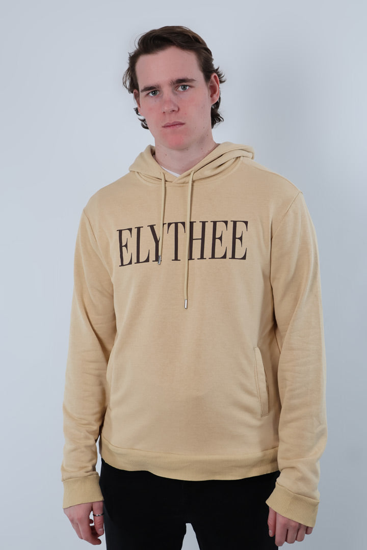 A person wearing a Nectar Nomad Hoodie, a chic unisex hoodie with ELYTHEE prominently showcased, stands against a gray background.